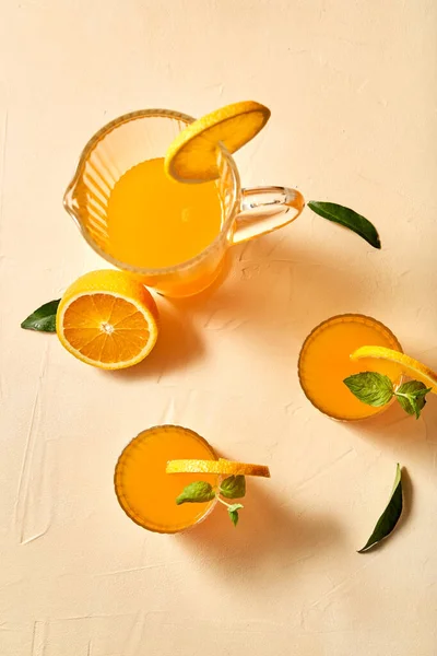 Gläser mit Orangensaft und Pfefferminze auf dem Tisch — Stockfoto