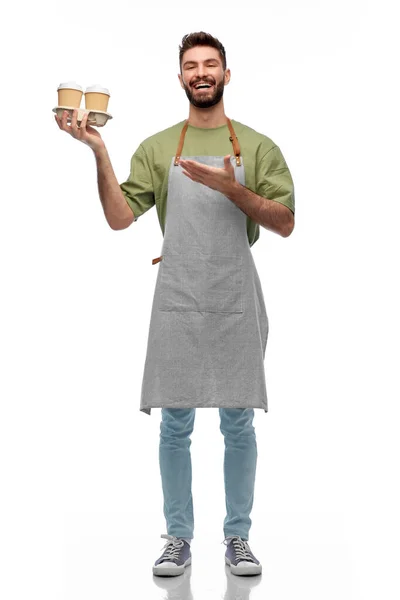 Happy smiling barman in apron with takeaway coffee — Stock Photo, Image