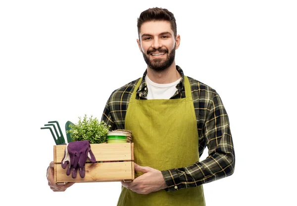 Glücklicher Gärtner oder Bauer mit Kiste mit Gartengeräten — Stockfoto