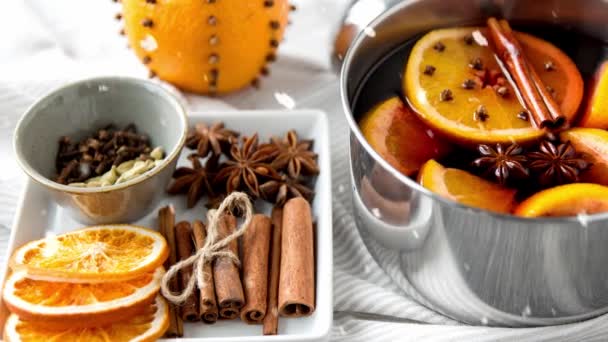 Gewürze und heißer Glühwein mit Orangenscheiben — Stockvideo