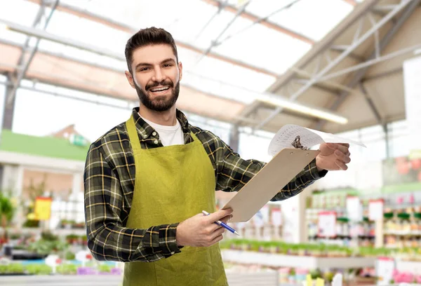Male gardener with clipboard at flower shop — Stock Photo, Image