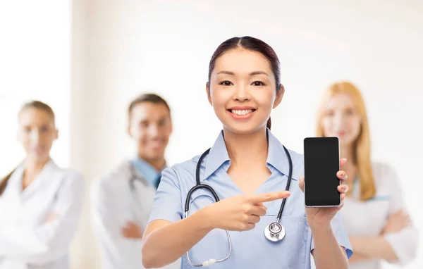 Glücklich asiatische Ärztin oder Krankenschwester mit Smartphone — Stockfoto