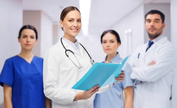 Sorridente médico feminino com colegas no hospital — Fotografia de Stock