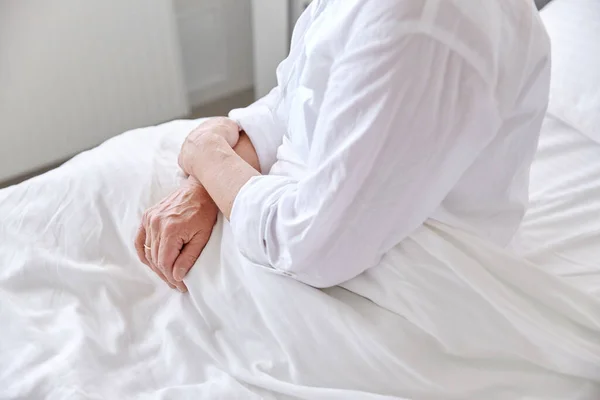 Lonely senior woman sitting in bed at hospital — Stock Photo, Image