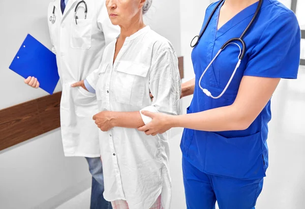 Mulher idosa, médico e enfermeiro no hospital — Fotografia de Stock