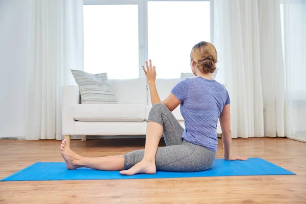 Mujer haciendo ejercicio de giro de yoga en casa — Foto de Stock