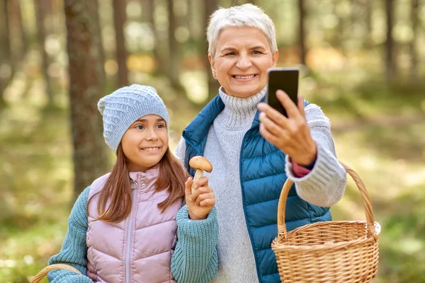 Oma mit Enkelin macht Selfie im Wald — Stockfoto