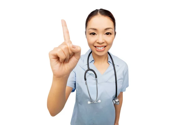 Feliz asiático mujer doctor apuntando dedo arriba —  Fotos de Stock