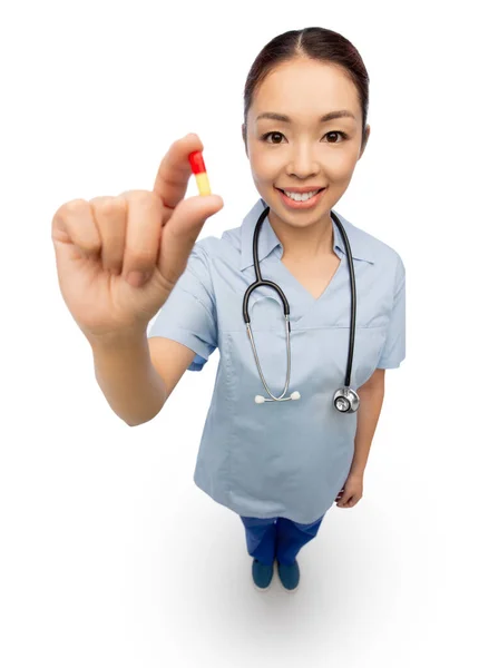 Asian doctor with medicine and glass of water — Stock Photo, Image