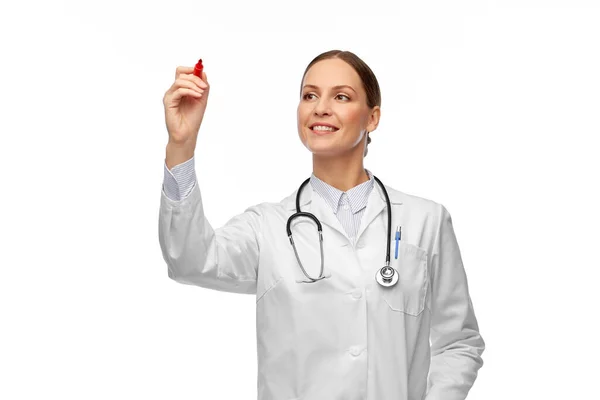 Ευτυχισμένη γυναίκα γιατρός γραφής με κόκκινο δείκτη — Φωτογραφία Αρχείου