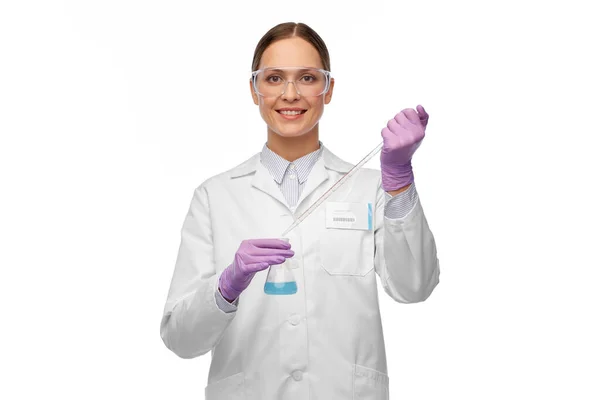 Wissenschaftlerin in Schutzbrille mit Chemikalie im Kolben — Stockfoto