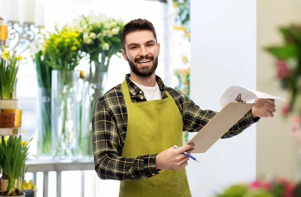 Male gardener with clipboard at flower shop — Stock Photo, Image