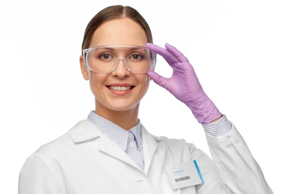 Lächelnde Wissenschaftlerin mit Brille und Handschuhen — Stockfoto