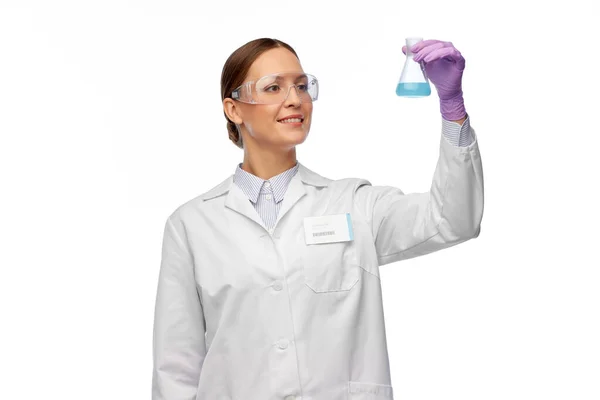 Női tudós szemüvegben kémiai anyaggal a lombikban — Stock Fotó