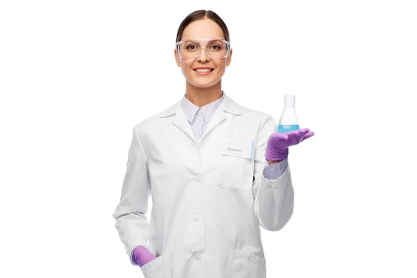 Wissenschaftlerin in Schutzbrille mit Chemikalie im Kolben — Stockfoto