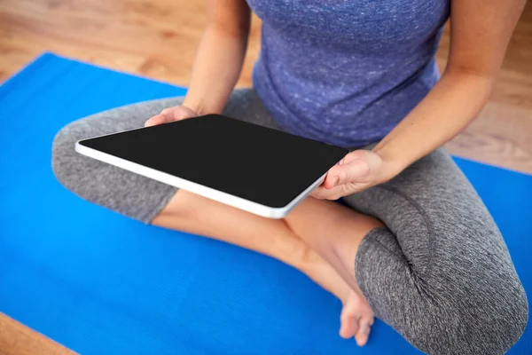 Vrouw met tablet pc computer doen yoga thuis — Stockfoto