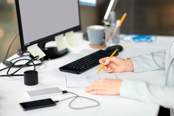 Zakenvrouw met notebook en computer op kantoor — Stockfoto