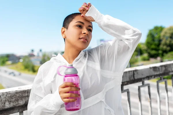 Mujer afroamericana bebiendo agua de la botella — Foto de Stock
