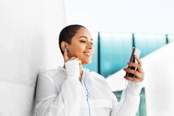 Donna afroamericana con auricolari e telefono — Foto Stock