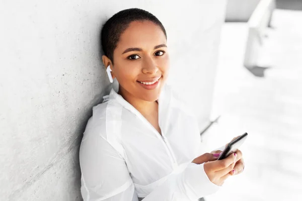 African american woman with earphones and phone — Stock Photo, Image