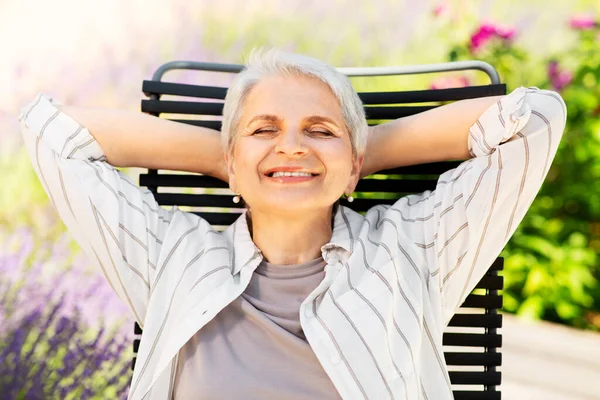 Mulher sênior feliz descansando no jardim de verão — Fotografia de Stock