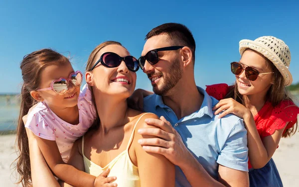 Yaz plajında güneş gözlüklü mutlu bir aile. — Stok fotoğraf