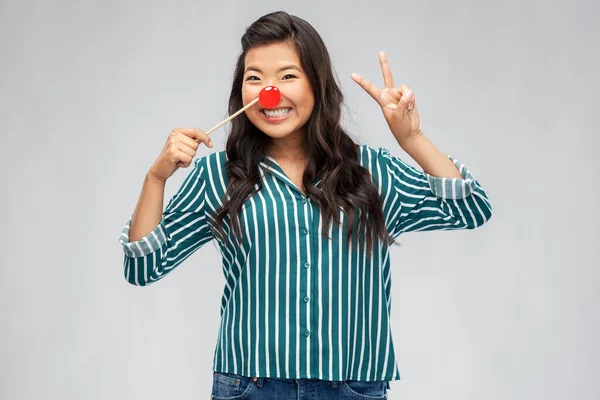 Feliz asiático mujer con rojo payaso nariz — Foto de Stock