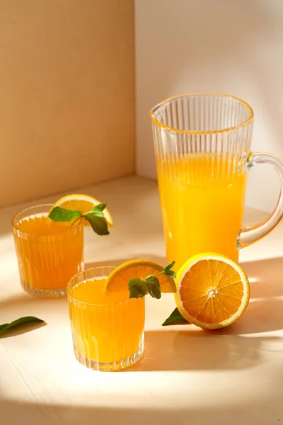 Vasos con zumo de naranja y menta sobre la mesa — Foto de Stock