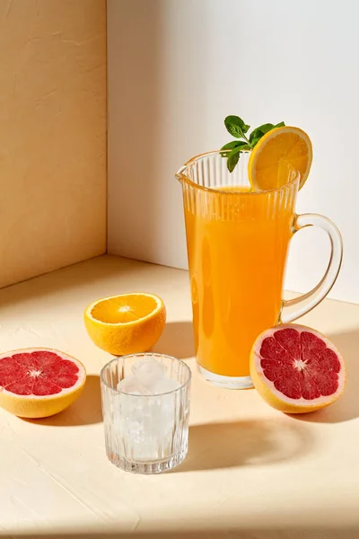 Orangensaft, Grapefruit und Eis im Glas auf dem Tisch — Stockfoto