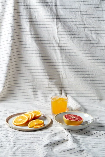 Grapefruit, sliced orange and glass of juice — Stock Photo, Image