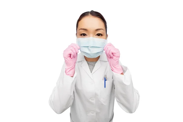 Aziatische vrouwelijke arts in medisch masker en handschoenen — Stockfoto