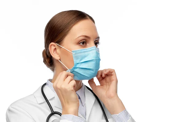 Ευτυχισμένη γυναίκα γιατρός φορώντας ιατρική μάσκα — Φωτογραφία Αρχείου