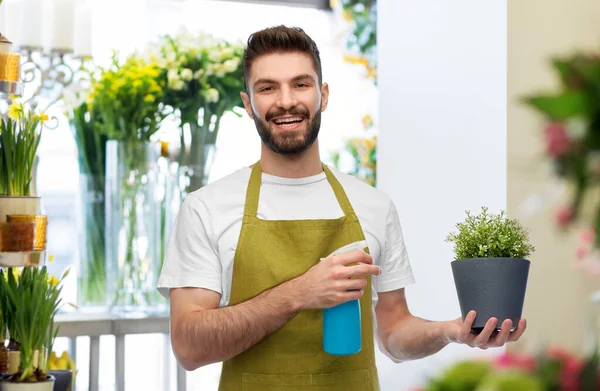 Feliz sonriente vendedor masculino hidratante flor — Foto de Stock