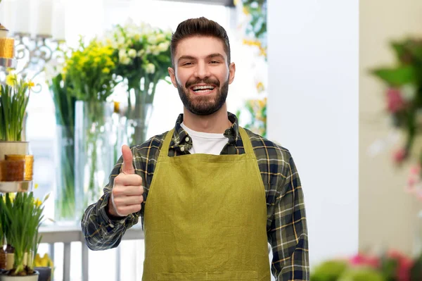 Szczęśliwy samiec sprzedawca pokazując kciuki w górę w kwiaciarnia — Zdjęcie stockowe