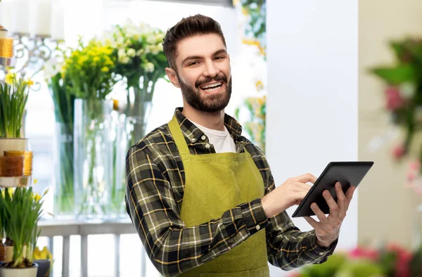 Vendedor masculino feliz com tablet pc na loja de flores — Fotografia de Stock