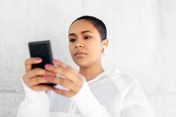 Mulher americana africana com fones de ouvido e telefone — Fotografia de Stock