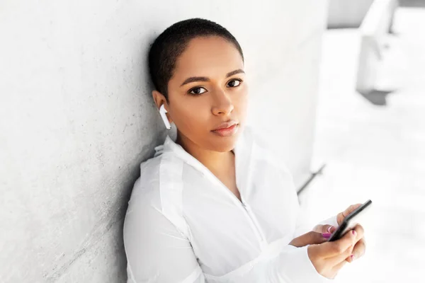 Afrikaans amerikaanse vrouw met koptelefoon en telefoon — Stockfoto