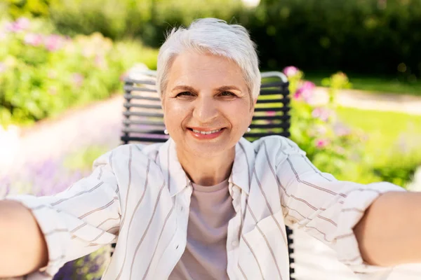 Heureuse femme âgée prenant selfie au jardin d'été — Photo