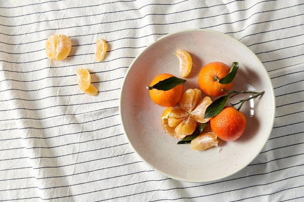 Vida tranquila com mandarinas na placa sobre cortinas — Fotografia de Stock