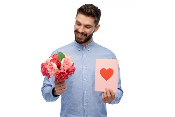 Glücklicher Mann mit Blumen und Valentinstag-Karte — Stockfoto