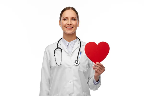 Doctora sonriente con corazón y estetoscopio — Foto de Stock