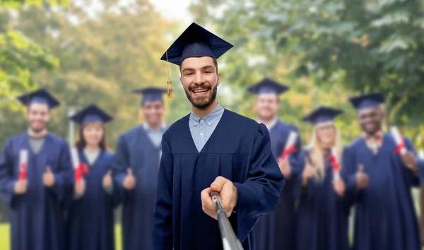 Mannelijke afgestudeerde student nemen selfie met monopod — Stockfoto
