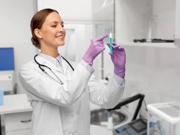 Glad kvinnlig läkare med spruta på sjukhus — Stockfoto