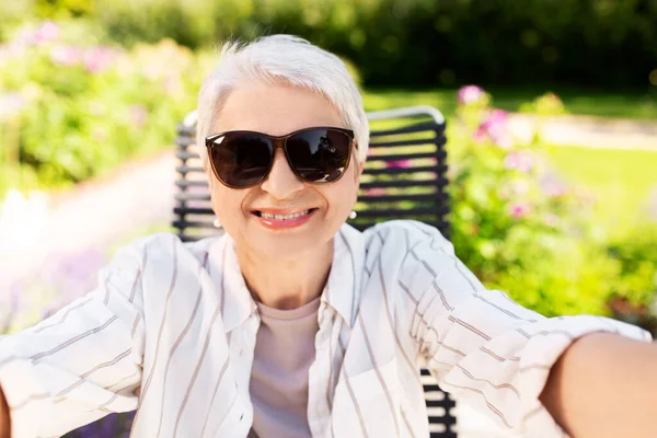 Felice donna anziana prendendo selfie in giardino estivo — Foto Stock