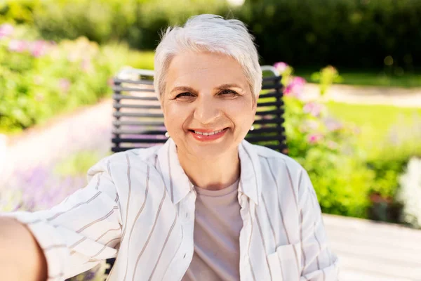 Gelukkig senior vrouw het nemen van selfie in de zomer tuin — Stockfoto