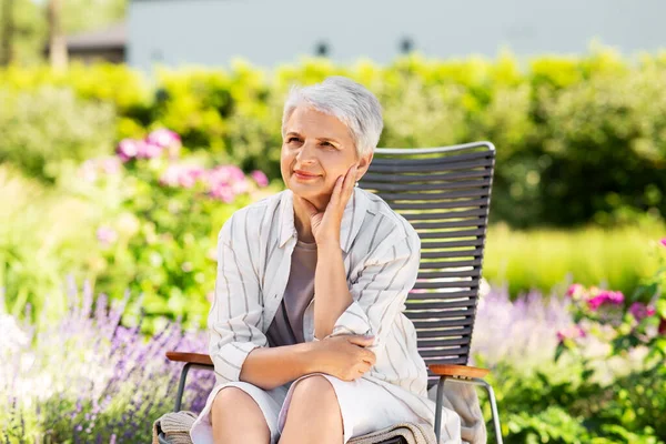 Felice donna anziana che riposa nel giardino estivo — Foto Stock