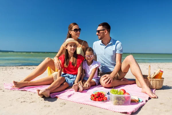 Família feliz fazendo piquenique na praia de verão — Fotografia de Stock