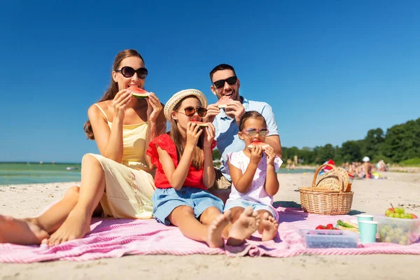 Família feliz fazendo piquenique na praia de verão — Fotografia de Stock