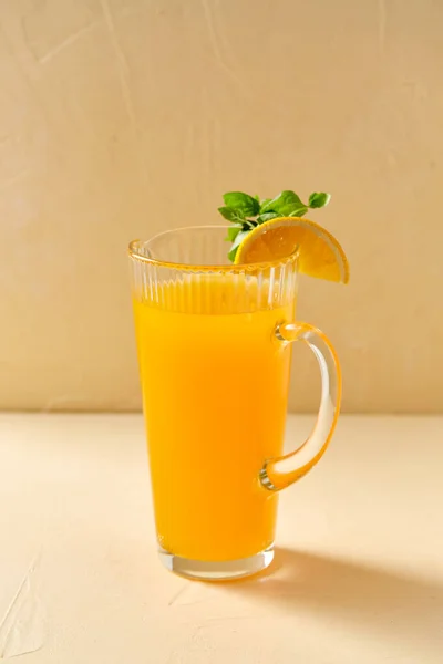 Jarra con zumo de naranja y menta en la mesa — Foto de Stock