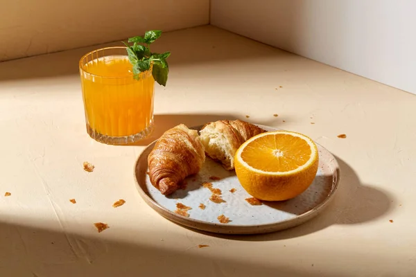 Verre de jus d'orange et croissant sur assiette — Photo